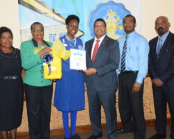 Third Place receives prize- L-R, Ms. Patricia Innis (essay coach), Mrs. Rosemary Pintard-Bowe (Acting D.I.R Controller), D'Asia Russell (awardee), Hon. K Peter Turnquest (DPM, Min Of Finance), Mr. Chester Cooper (principal EMRH), Mr. Keith Worrell (D.I.R OIC Grand Bahama)